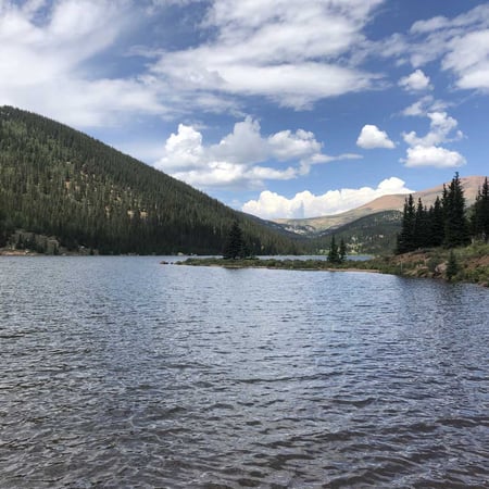 A mountainside lake flanked by pines on both sides.