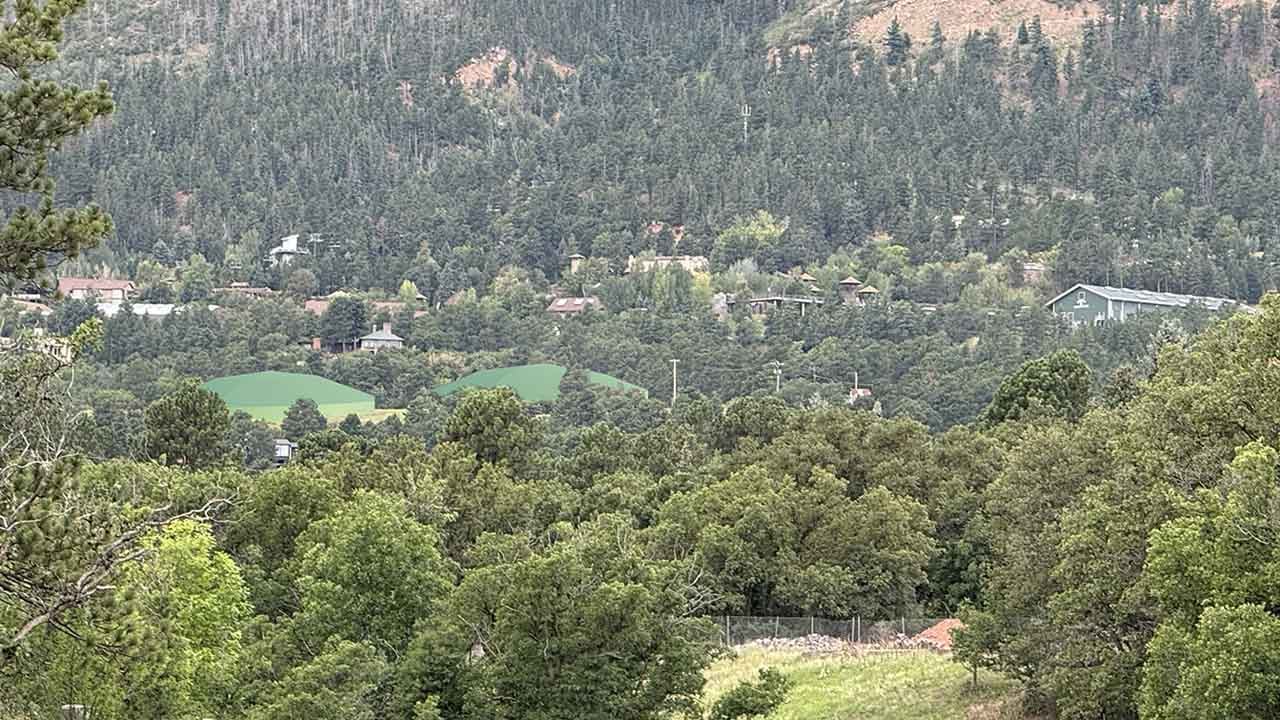 Rendering of the Penrose Water Supply Project from Poutales Park. There is two large curved green roofs of water tanks visible in the distance.