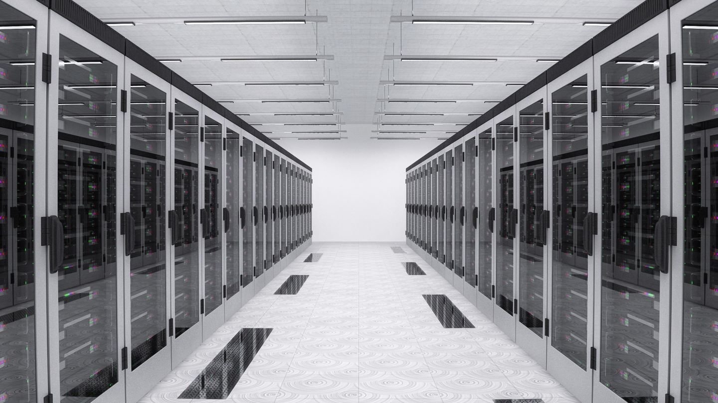The inside of a data center showing a long row of black server cabinets.