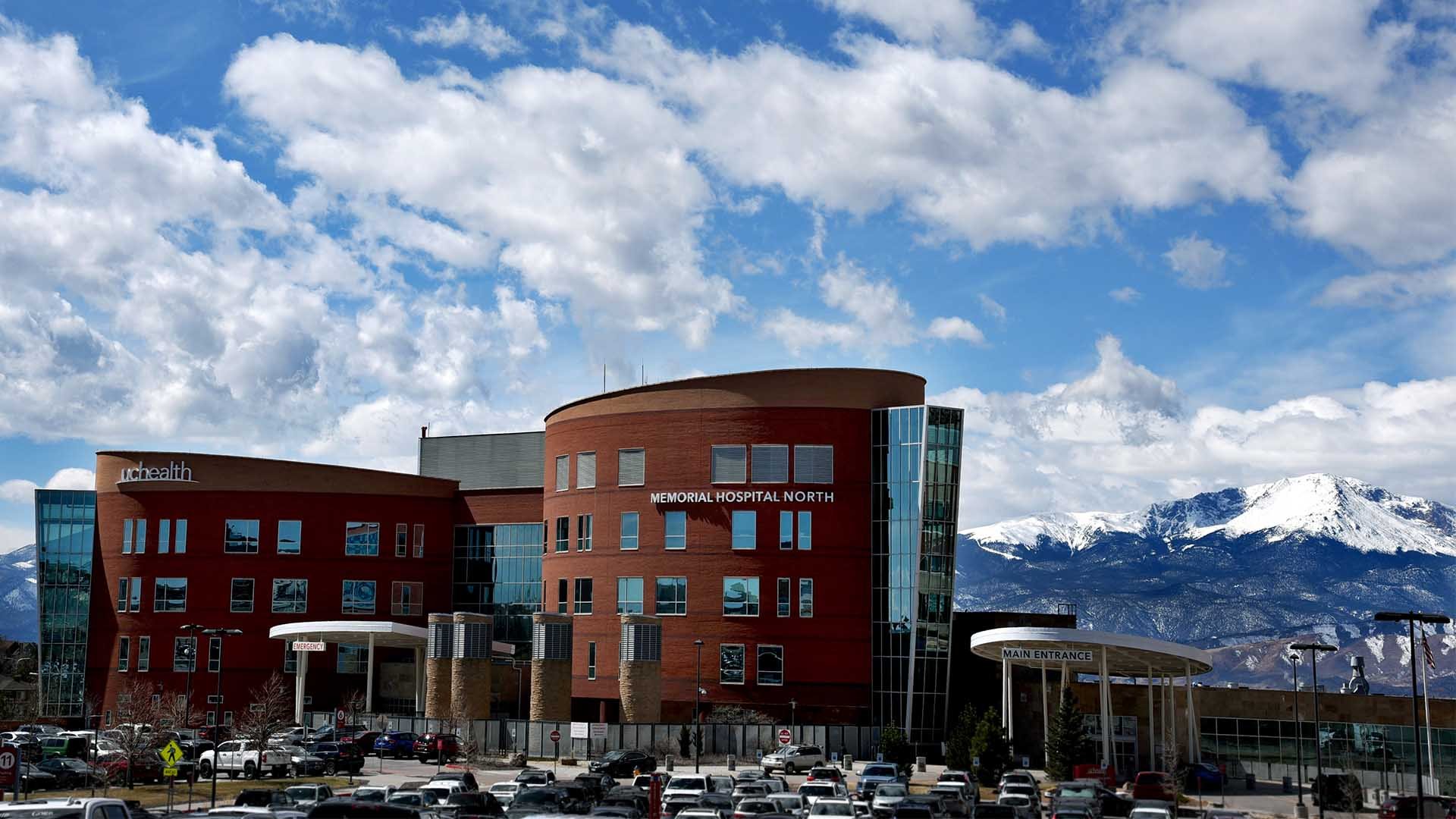 Foto del UCHealth Memorial North Hospital en un día parcialmente nublado. Pikes Peak es visible en el fondo.