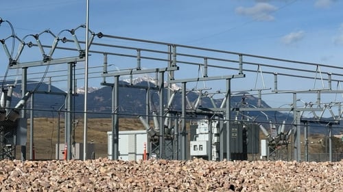 An electric substation with pikes peak visible in the background. 