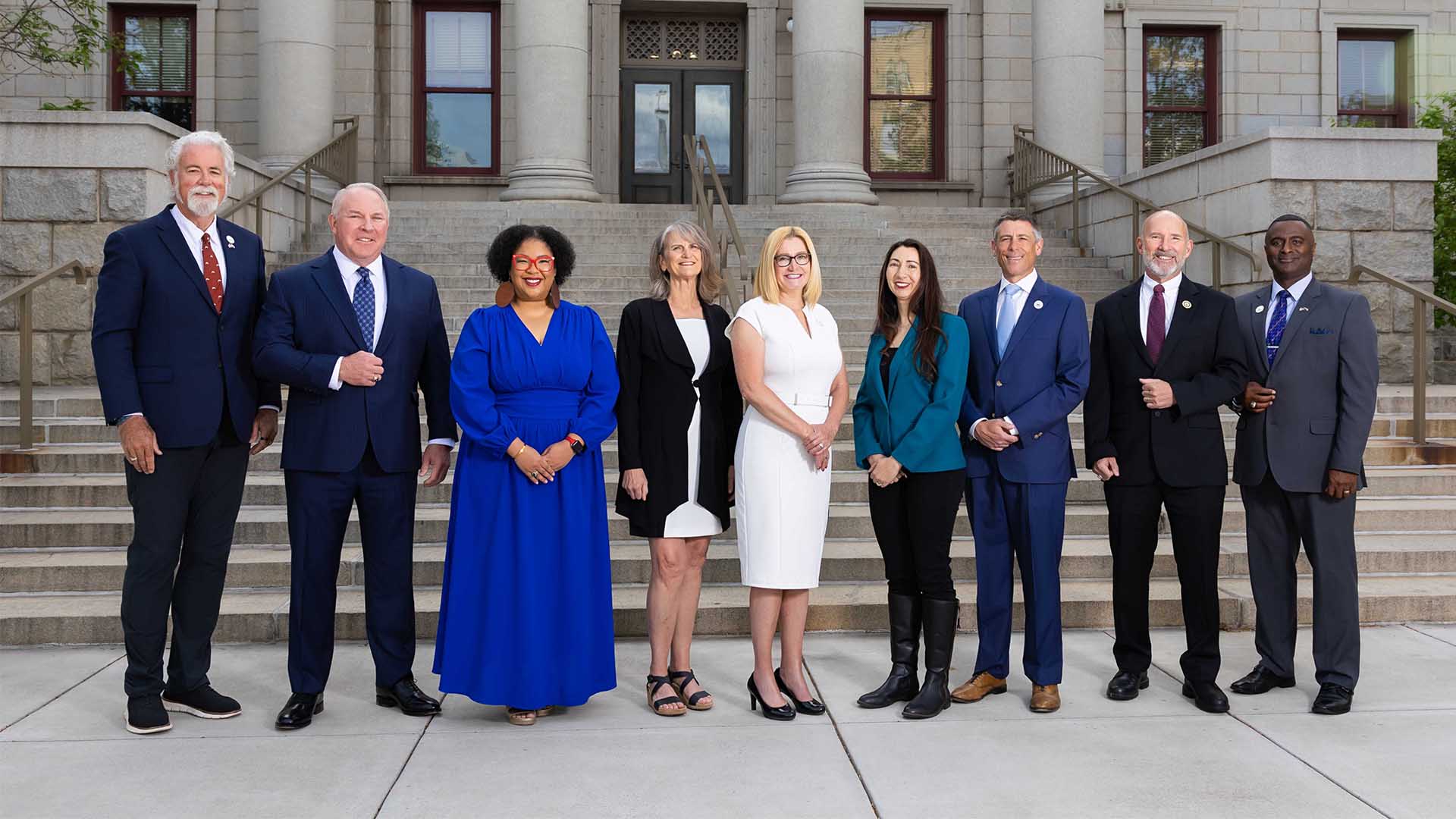 A group photograph of Colorado Springs Utilities Board members on the steps of city hall. Members pictured from left to right are David Leinweber, Ken Casey, Kimberly Gold, Nancy Henjum, Lynette Crow-Iverson, Brandy Williams, Brian Risley, Dave Donelson and Roland Rainey.