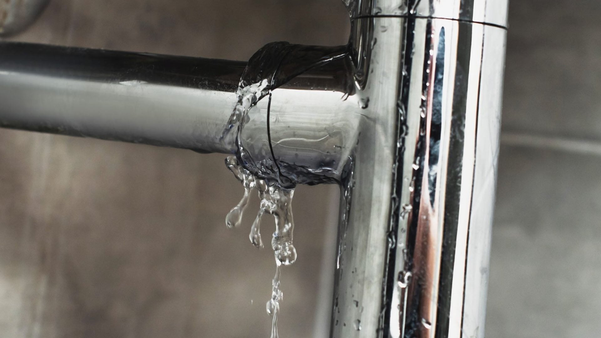 Metal pipe under a sink leaking water at the joint.