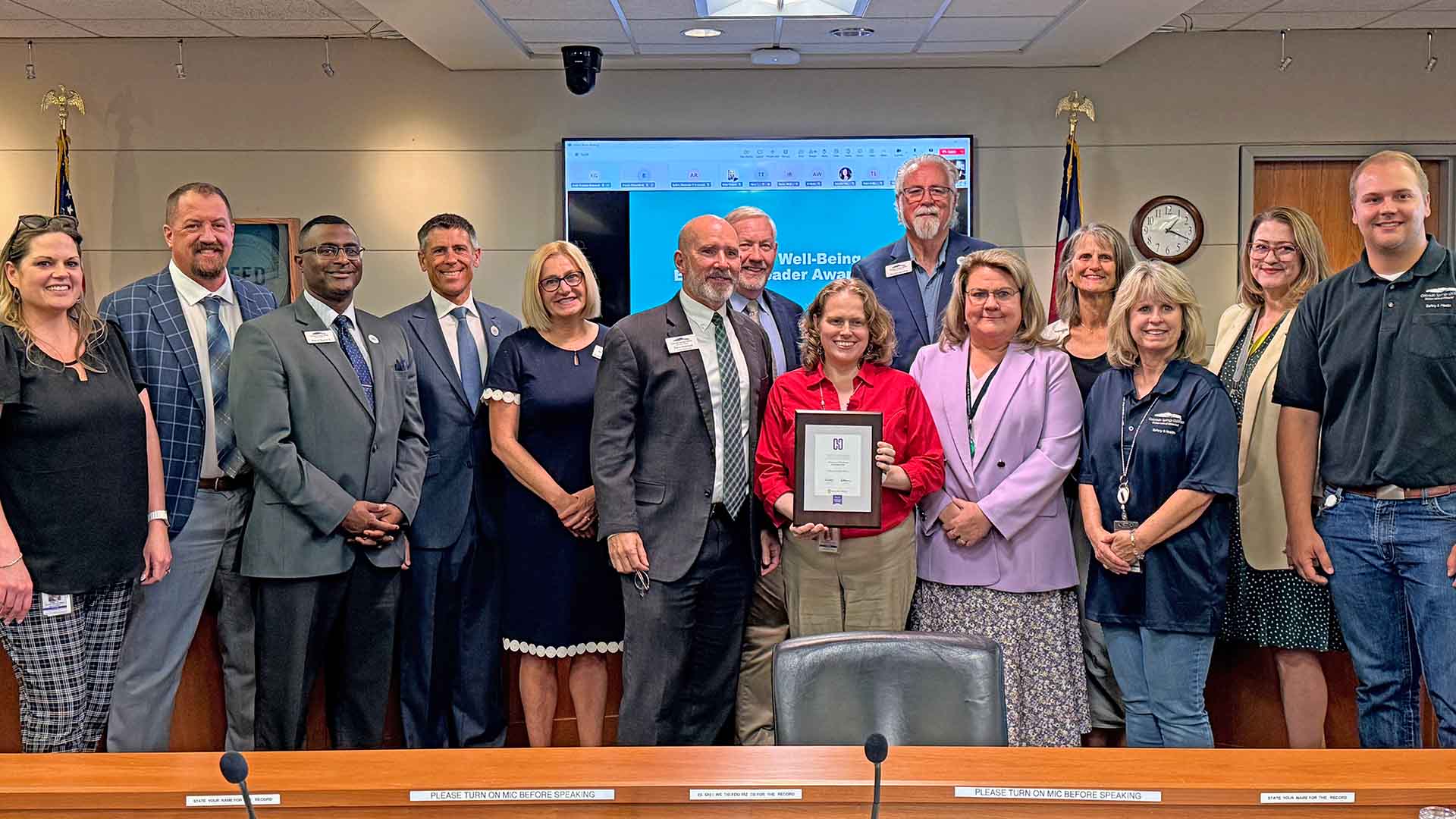 Group picture of Colorado Springs Utilities Manager Sara Akins standing next to Utilities Board members, Organization officers and employees.