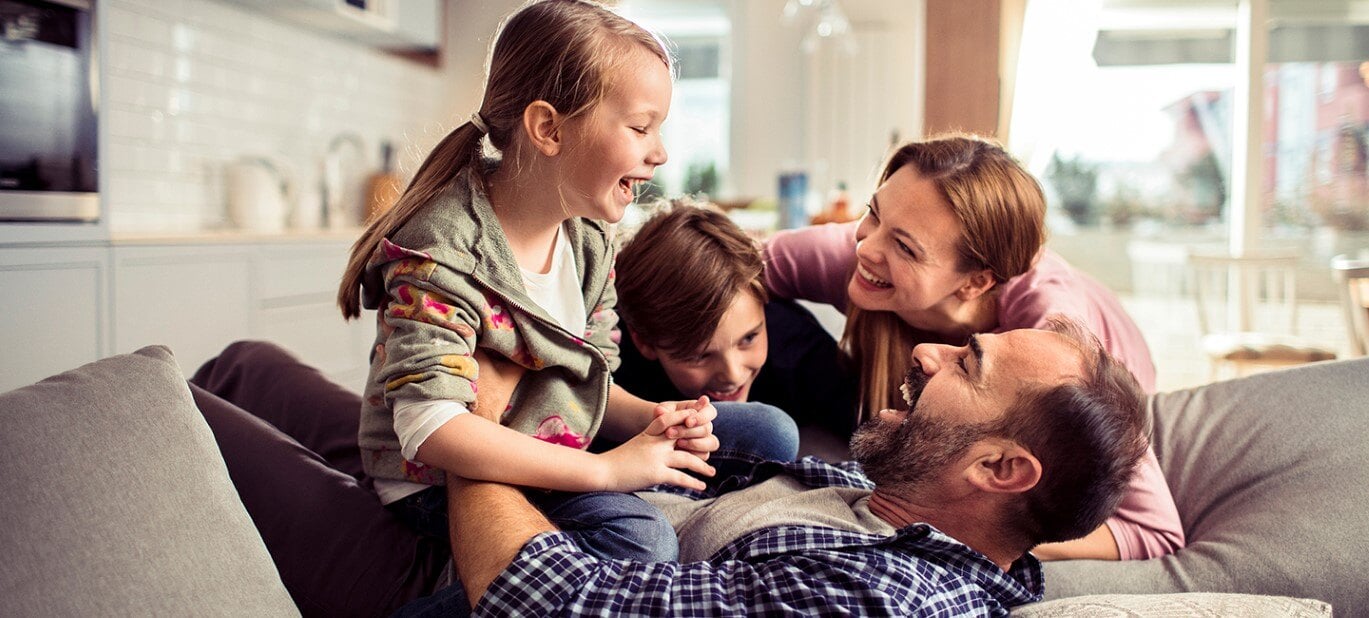 A family of four playing together in a brightly lit living room